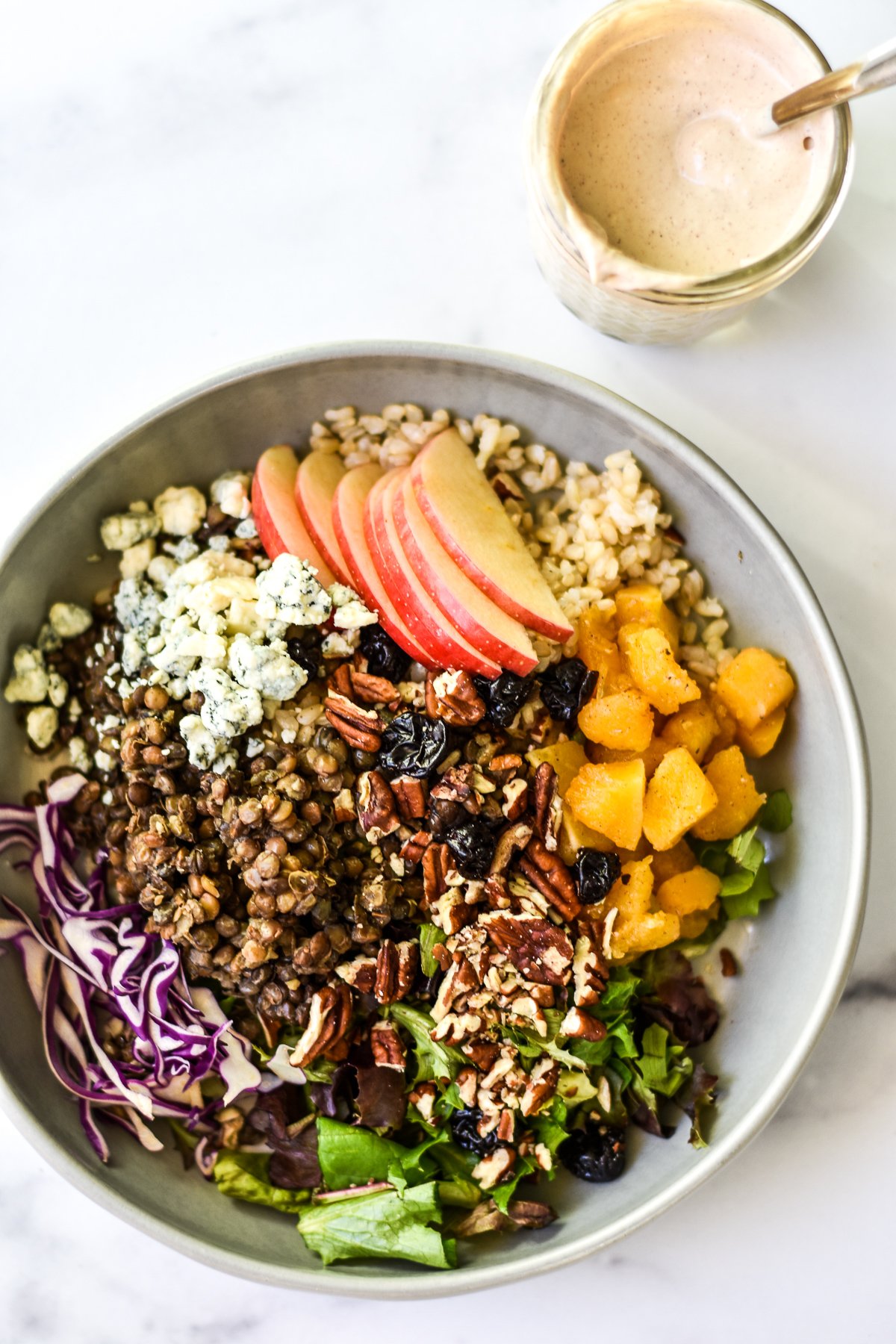 autumn rice bowl with a jar of creamy dressing on the side