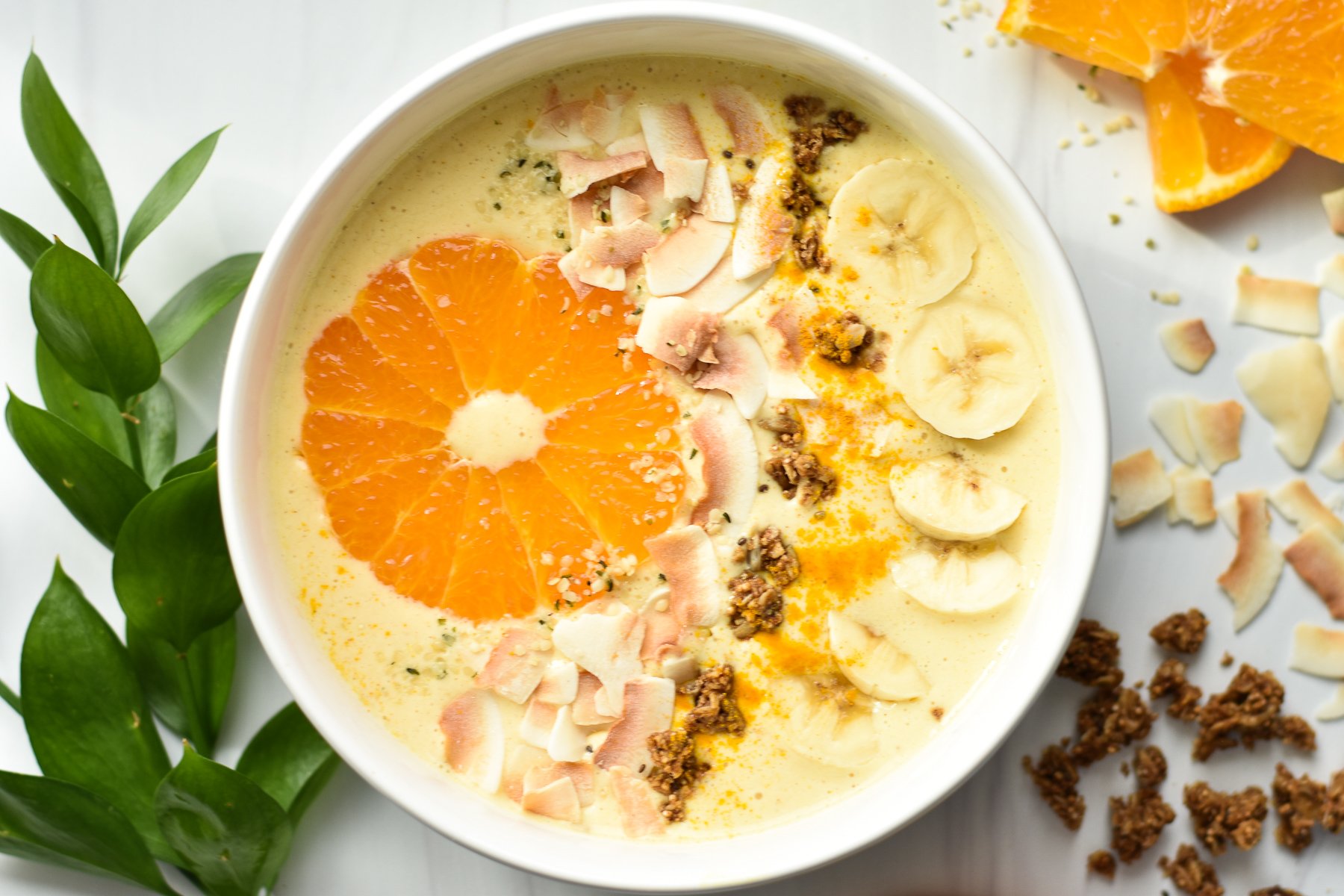 tropical smoothie bowl with an orange slice and granola