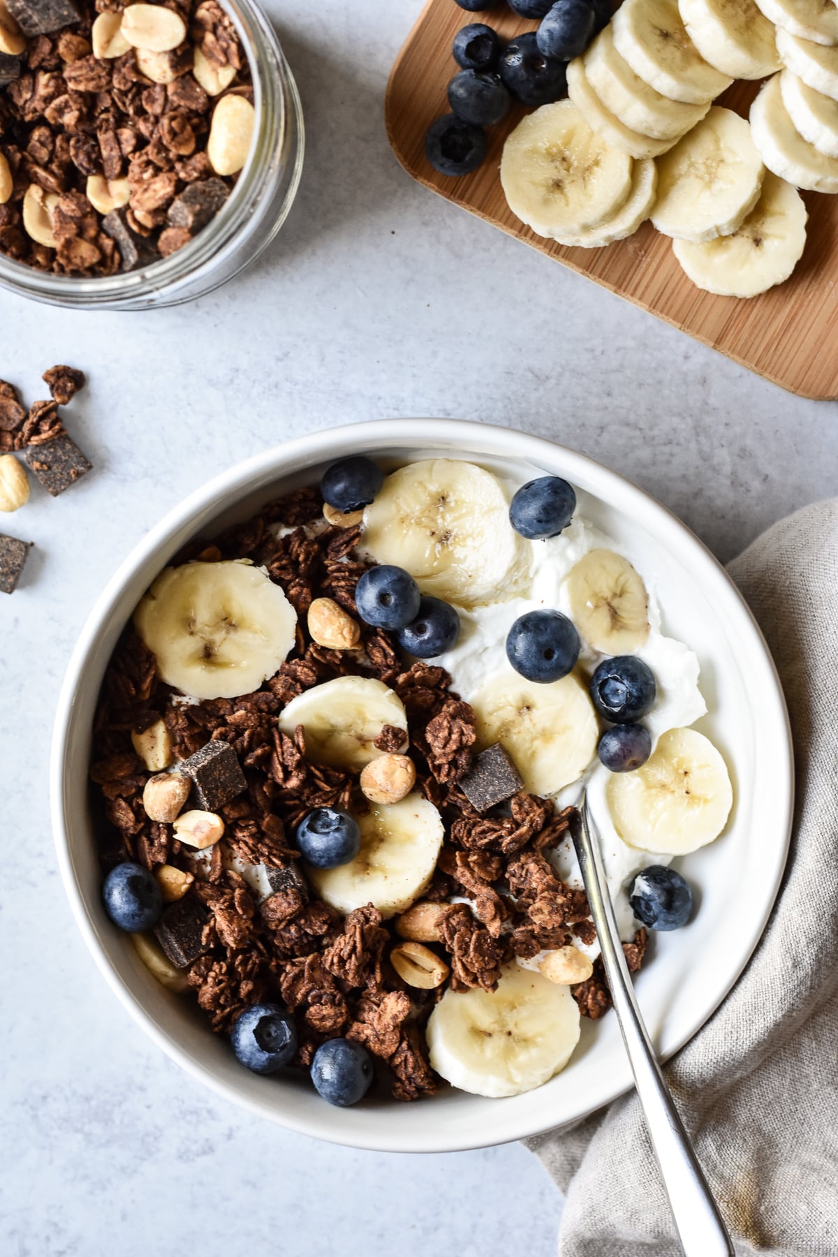 bowl of yogurt with chocolate peanut butter granola and bananas and blueberries.