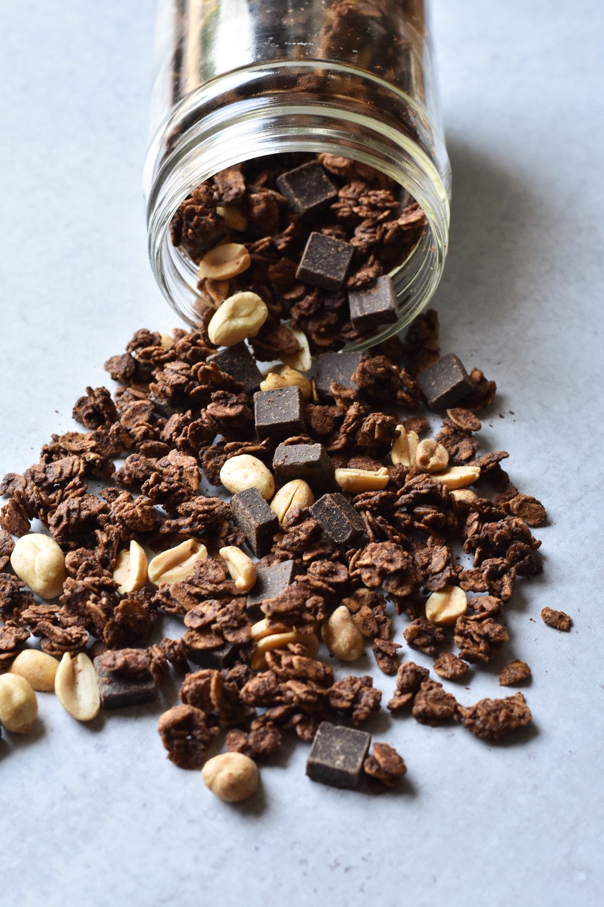 jar of granola with chocolate and peanuts spilling out