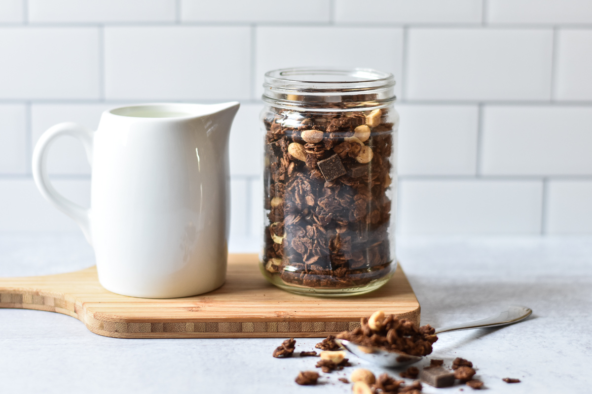 jar of chocolate peanut butter granola next to milk 