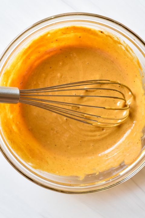 tahini sauce in a bowl with whisk