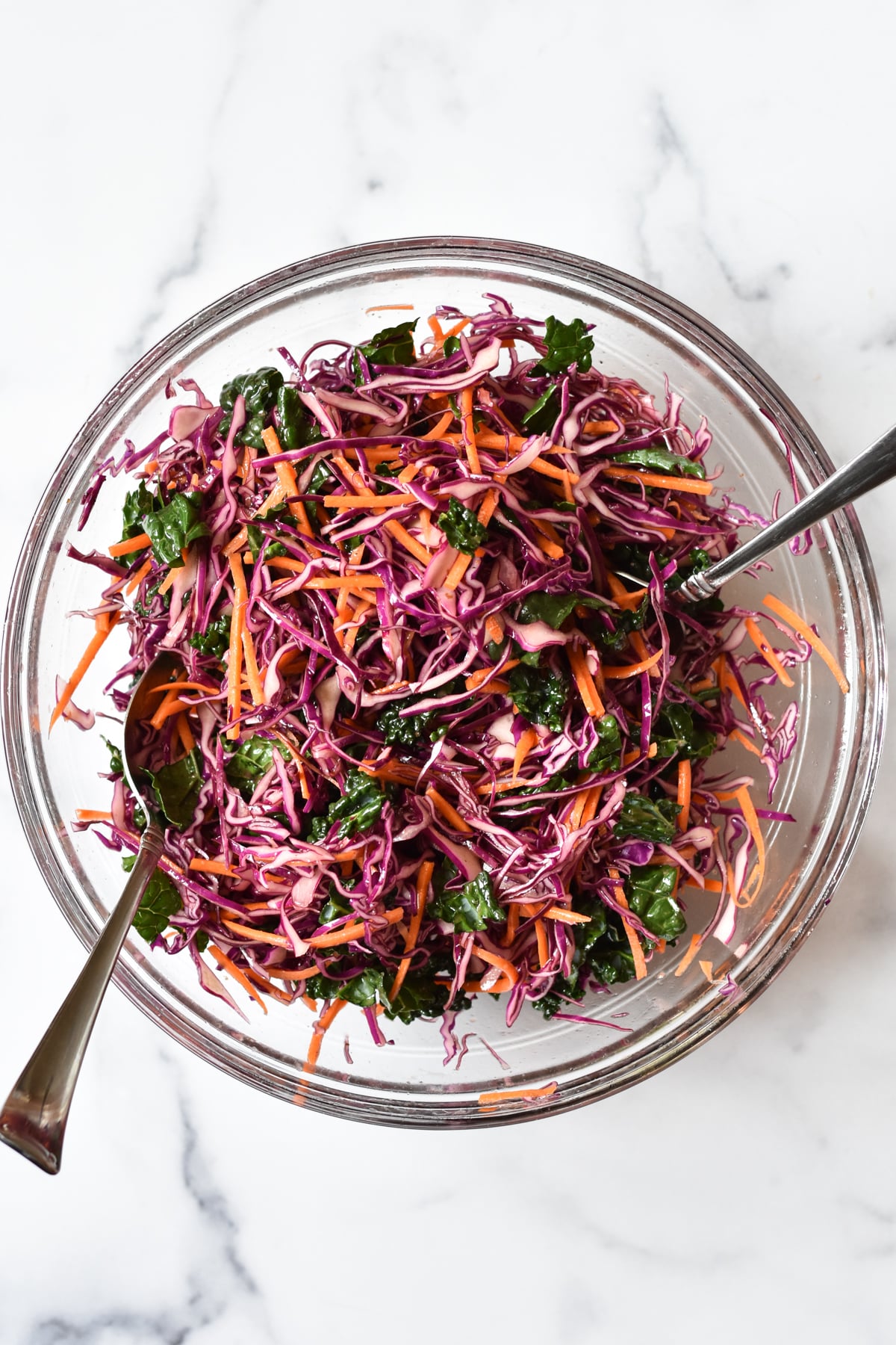 purple cabbage slaw in a large bowl with serving ware