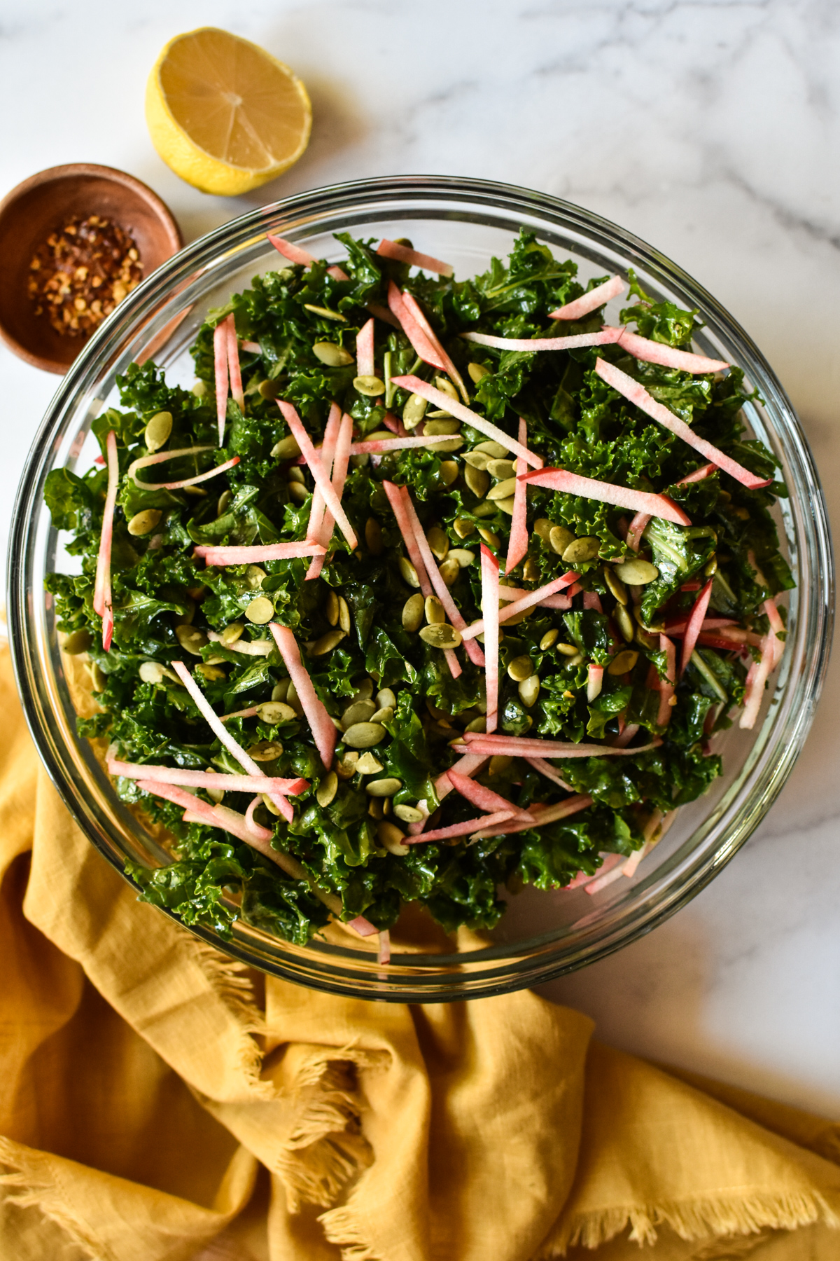 big bowl of kale crunch salad with apples and pepitas