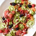 platter of citrus, kiwi, berries, pomegranate and fennel