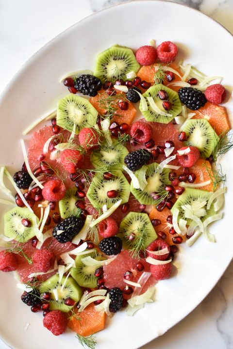 platter of citrus, kiwi, berries, pomegranate and fennel