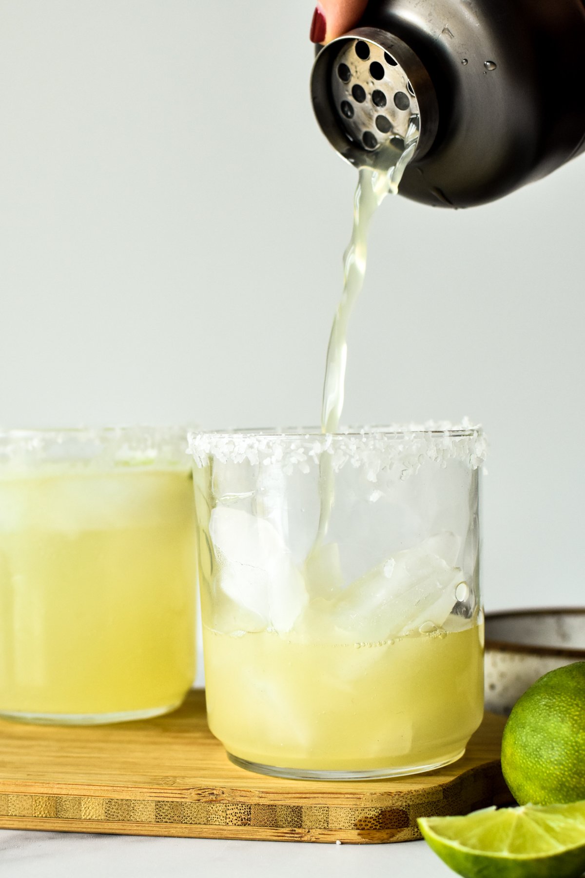 pouring a margarita mocktail into a glass of ice