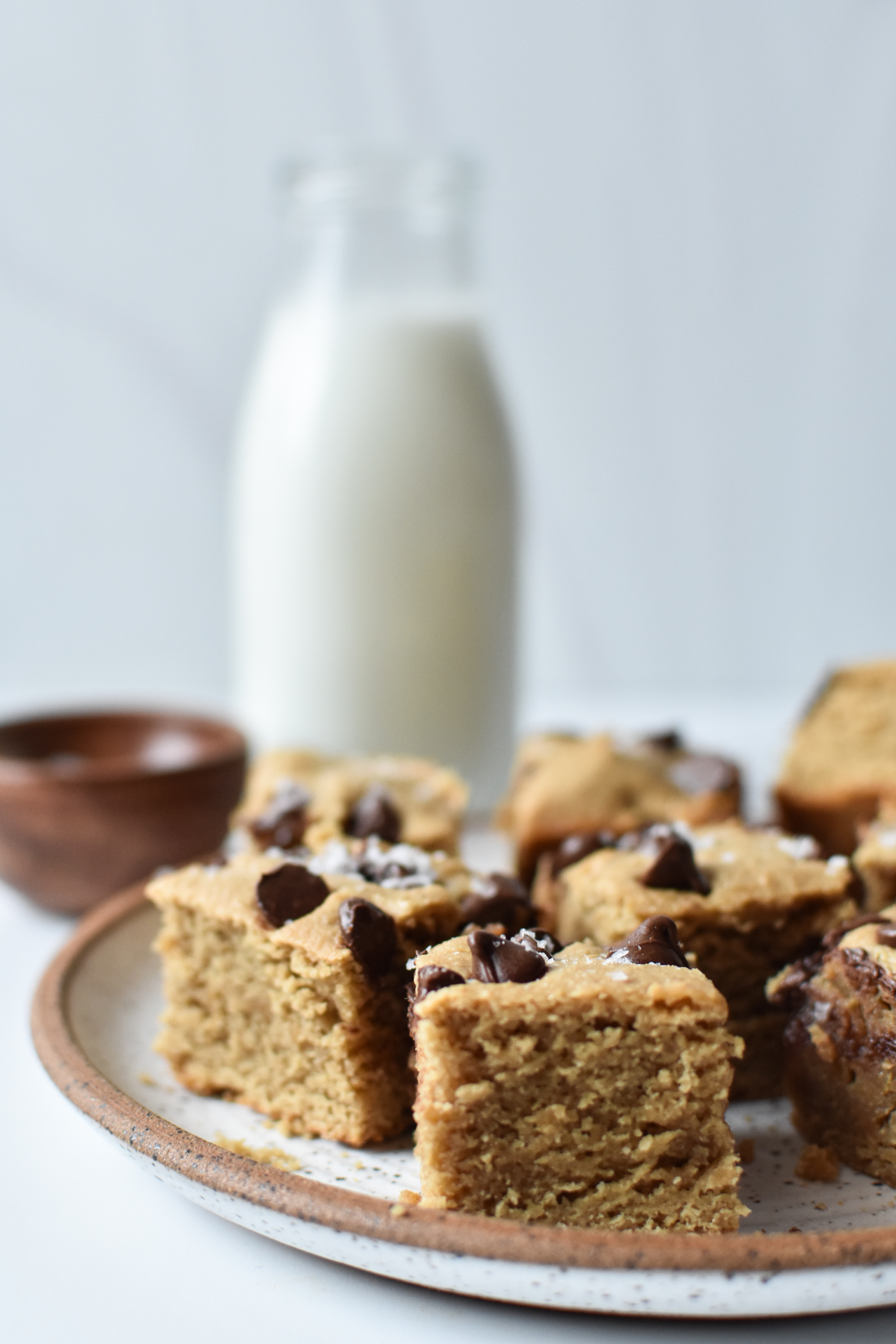 blondies with milk in the background