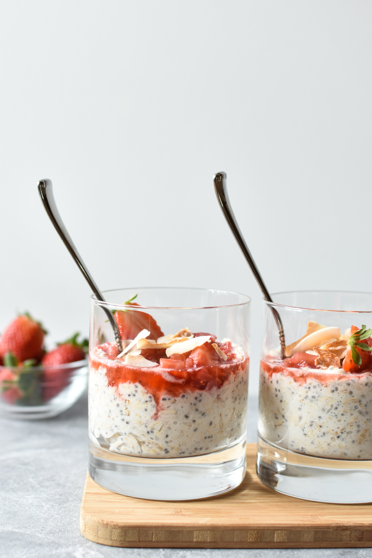 overnight oats in a glass with strawberries and coconut on top