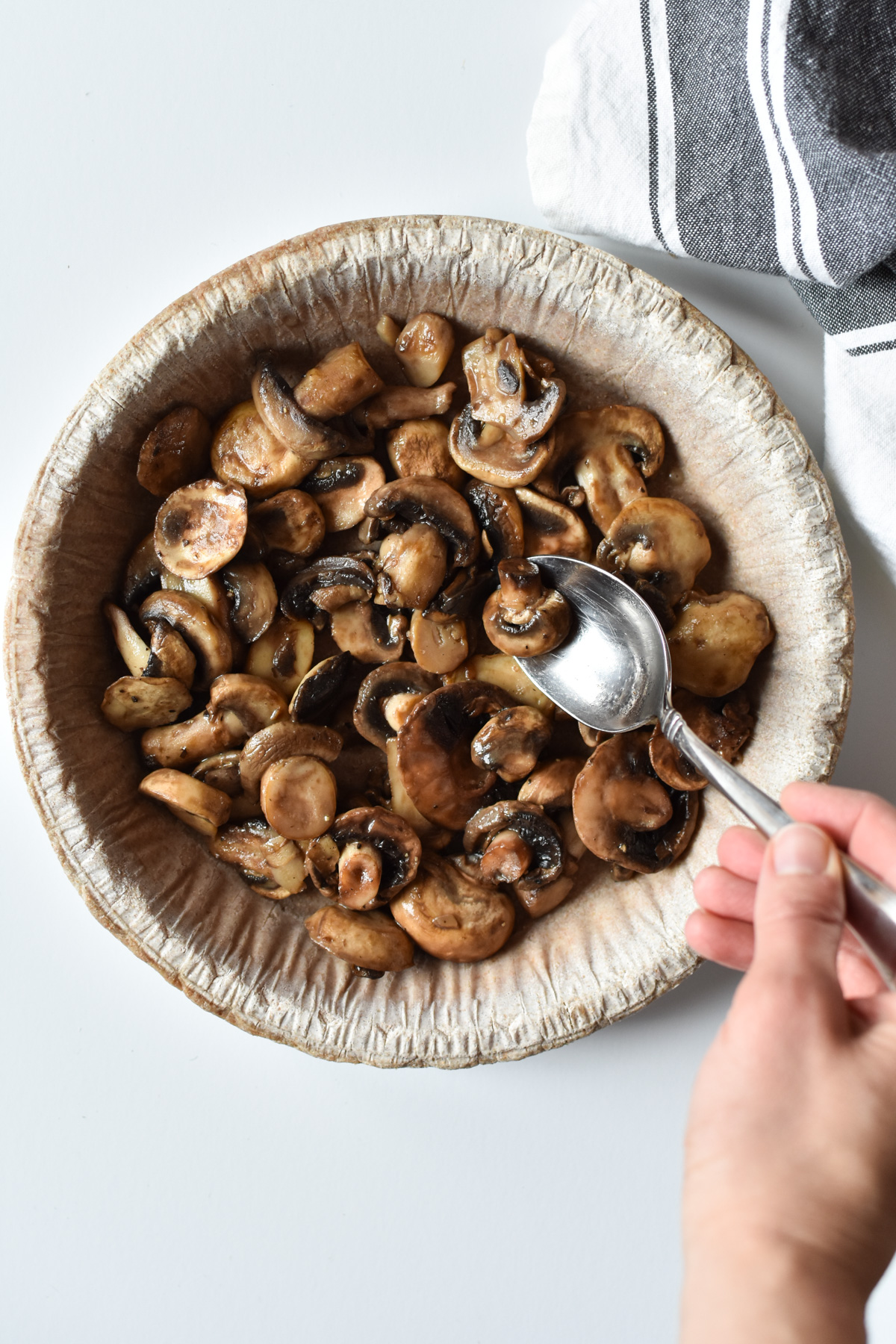 spooning mushrooms into a pie crust