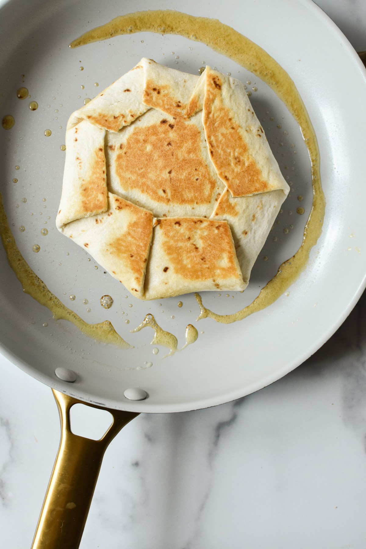 cooking crunchwrap in a skillet