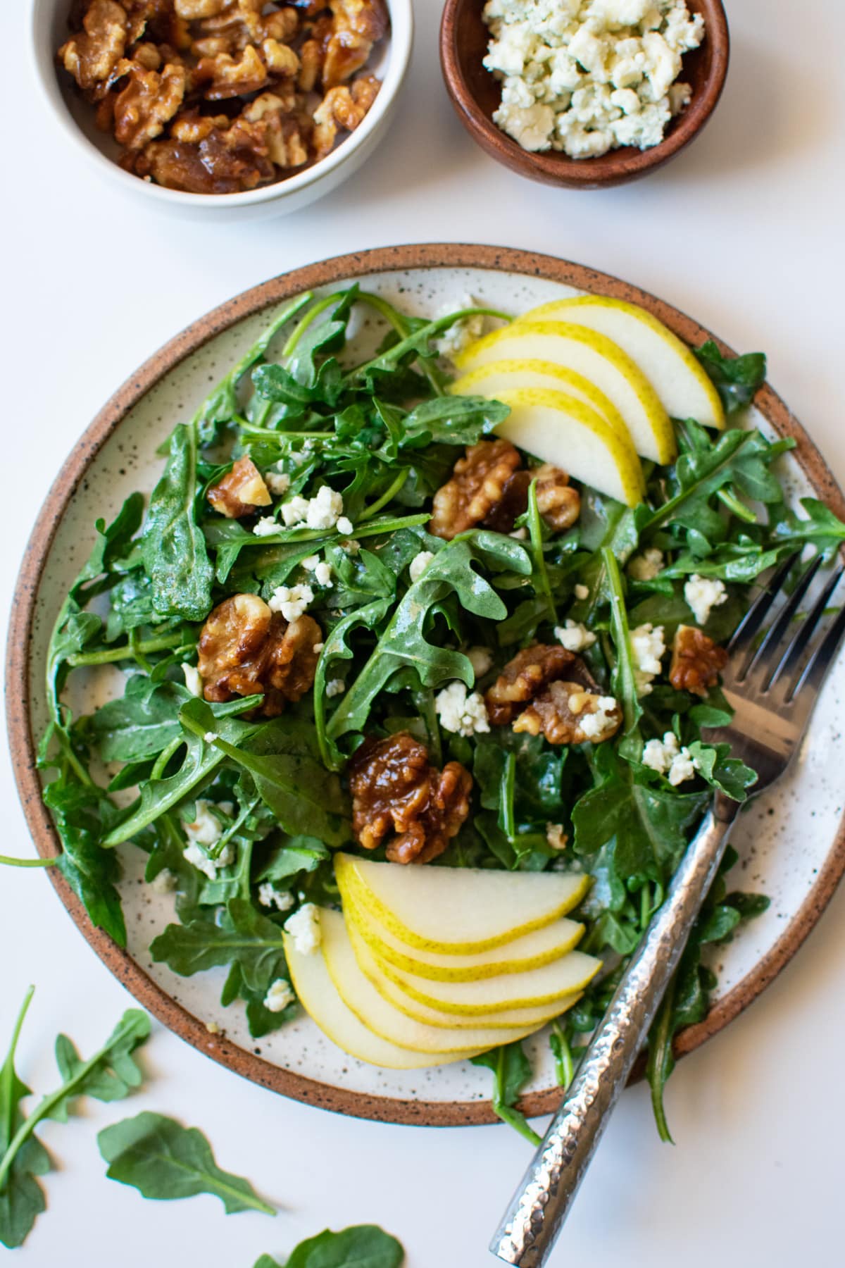 plated arugula pear salad with a fork