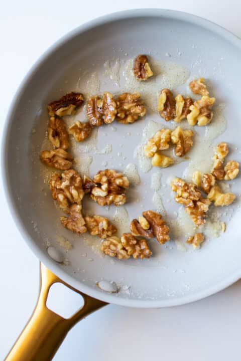 nonstick skillet with walnuts and melted sugar
