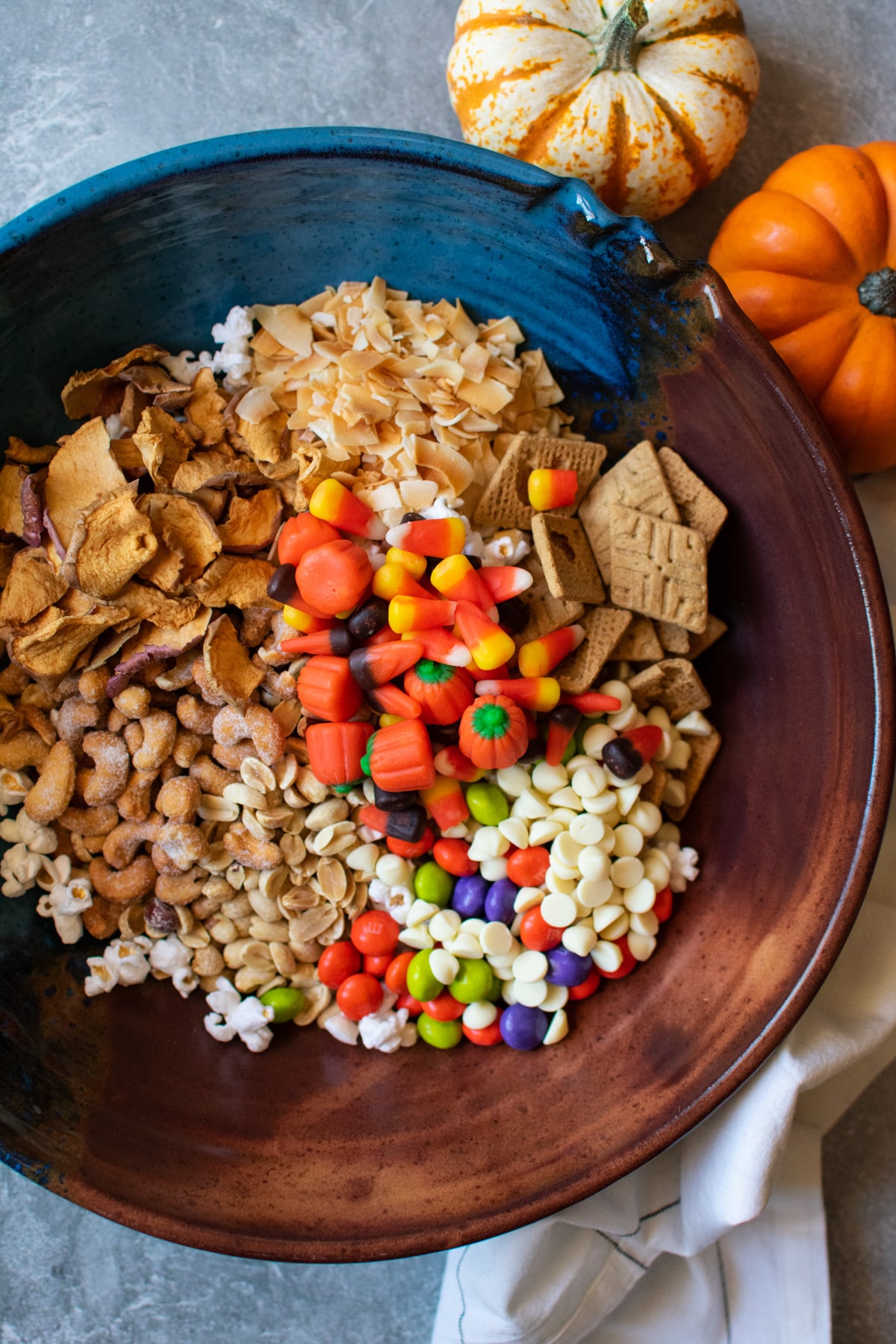 halloween snack mix ingredients in a bowl before being mixed together