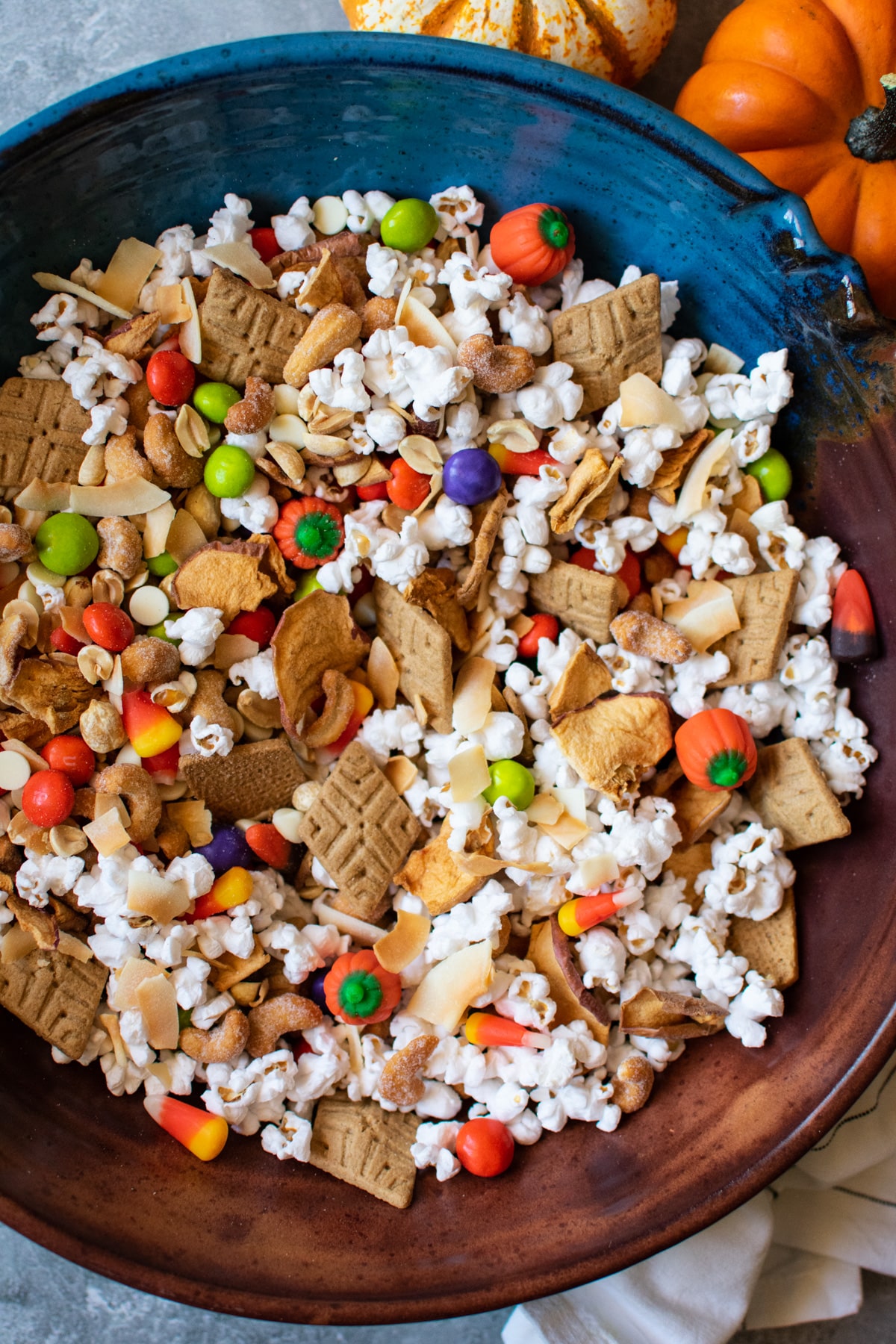 halloween snack mix in a large bowl with pumpkins in the background