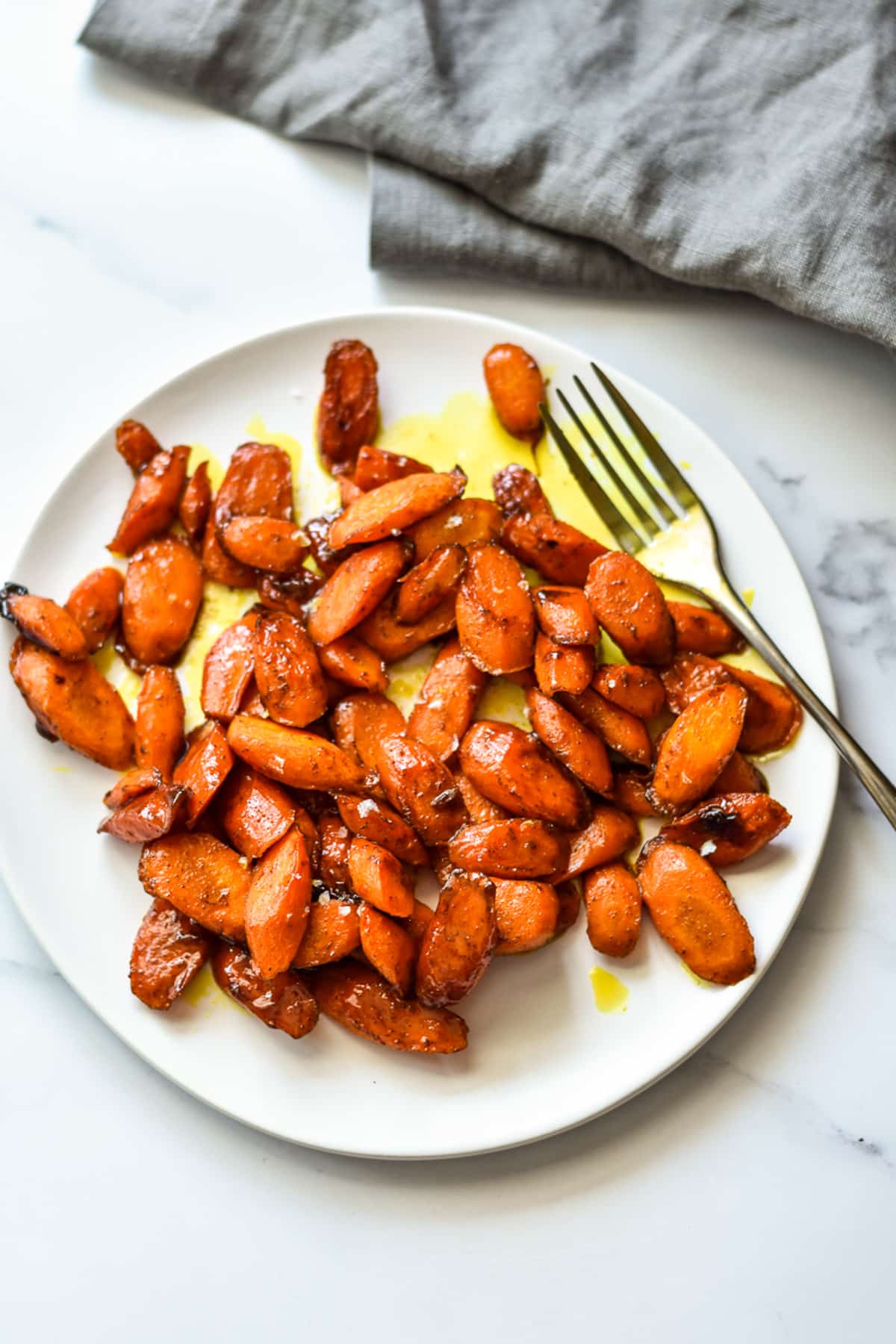 roasted carrots on a white plate with a fork