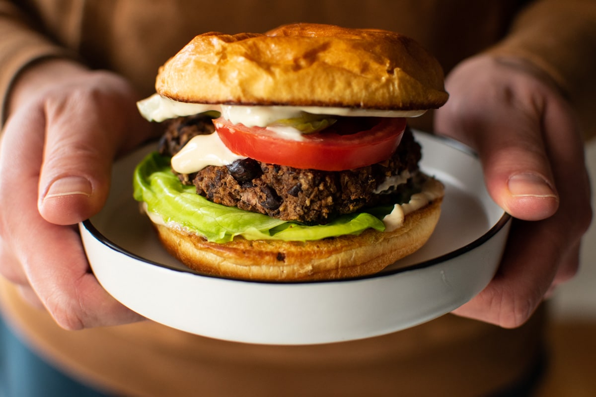 black bean burger on a plate with lettuce and tomato slice