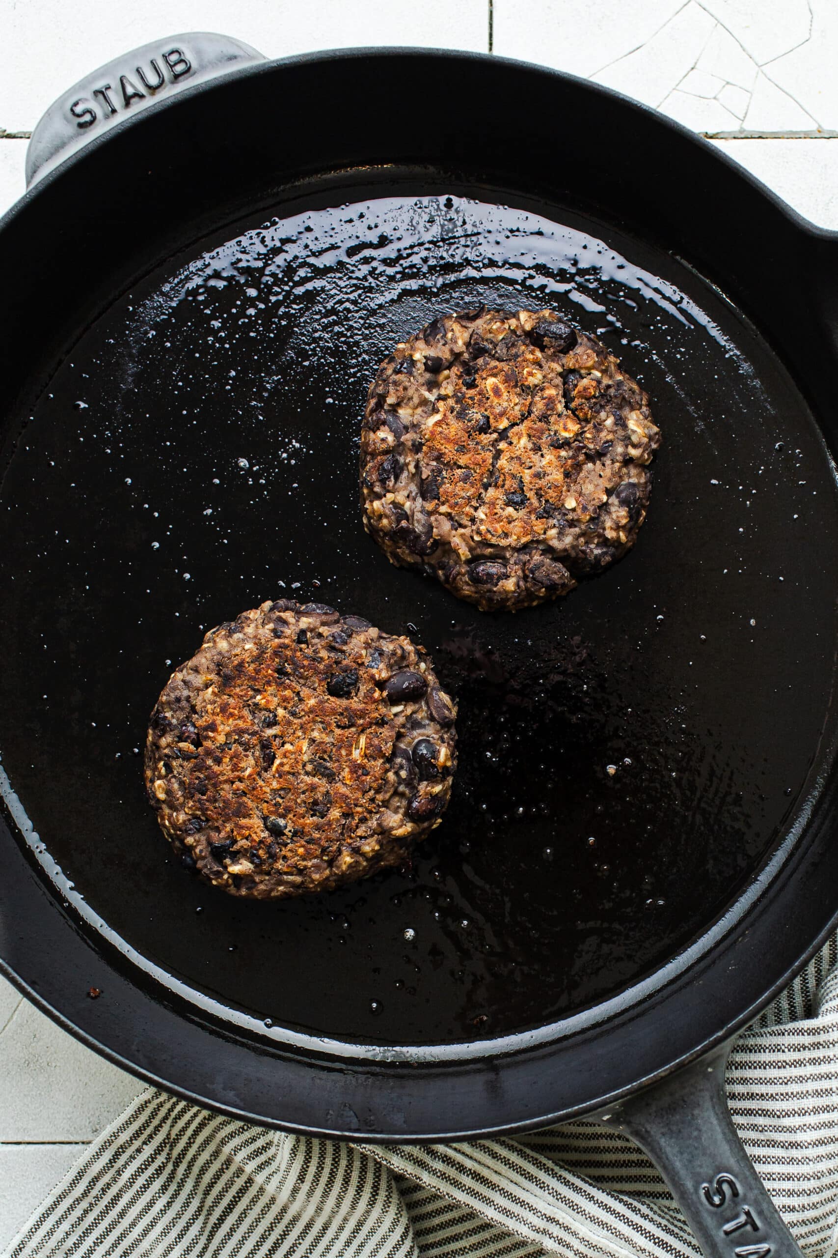 black bean burgers cooking in a skillet overhead view