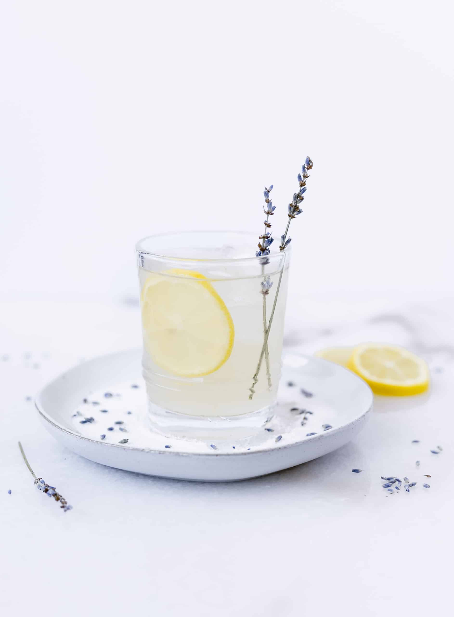 lavender lemonade cocktail with a sprig of lavender and a lemon slice in the glass