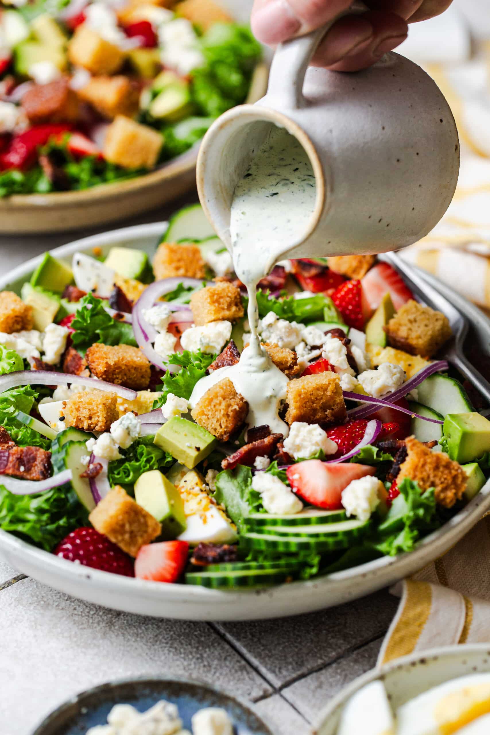 pouring dressing over a salad