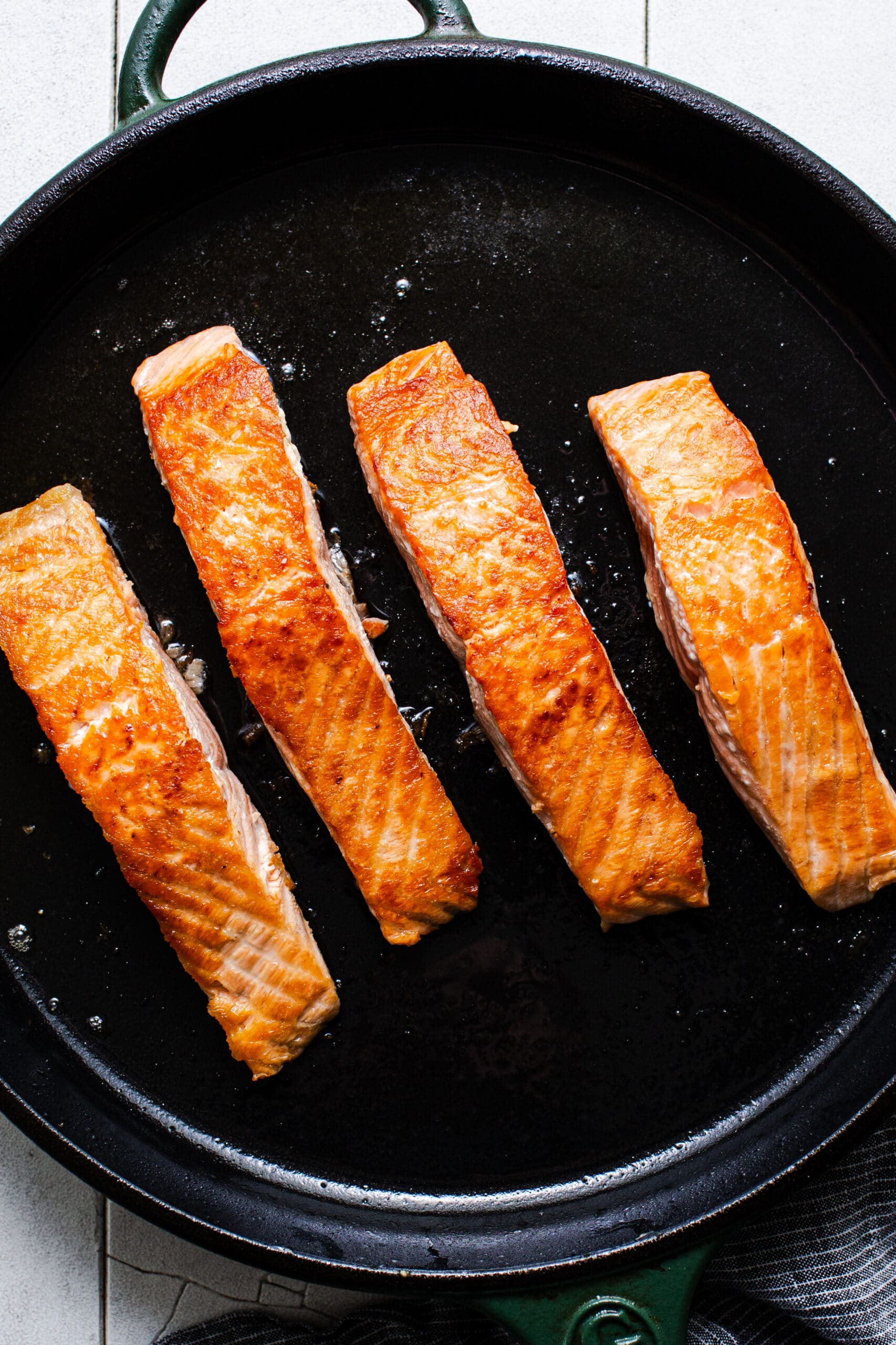 crispy salmon filets in a cast-iron skillet
